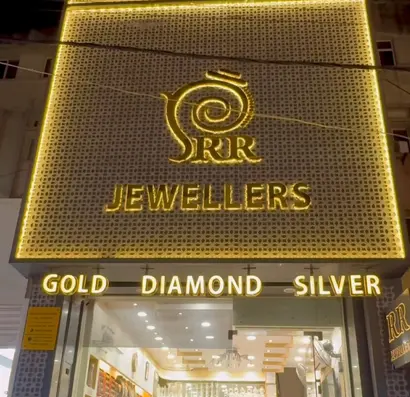 The RR Jewellers shopfront at night, its perforated golden screen glowing over the street.